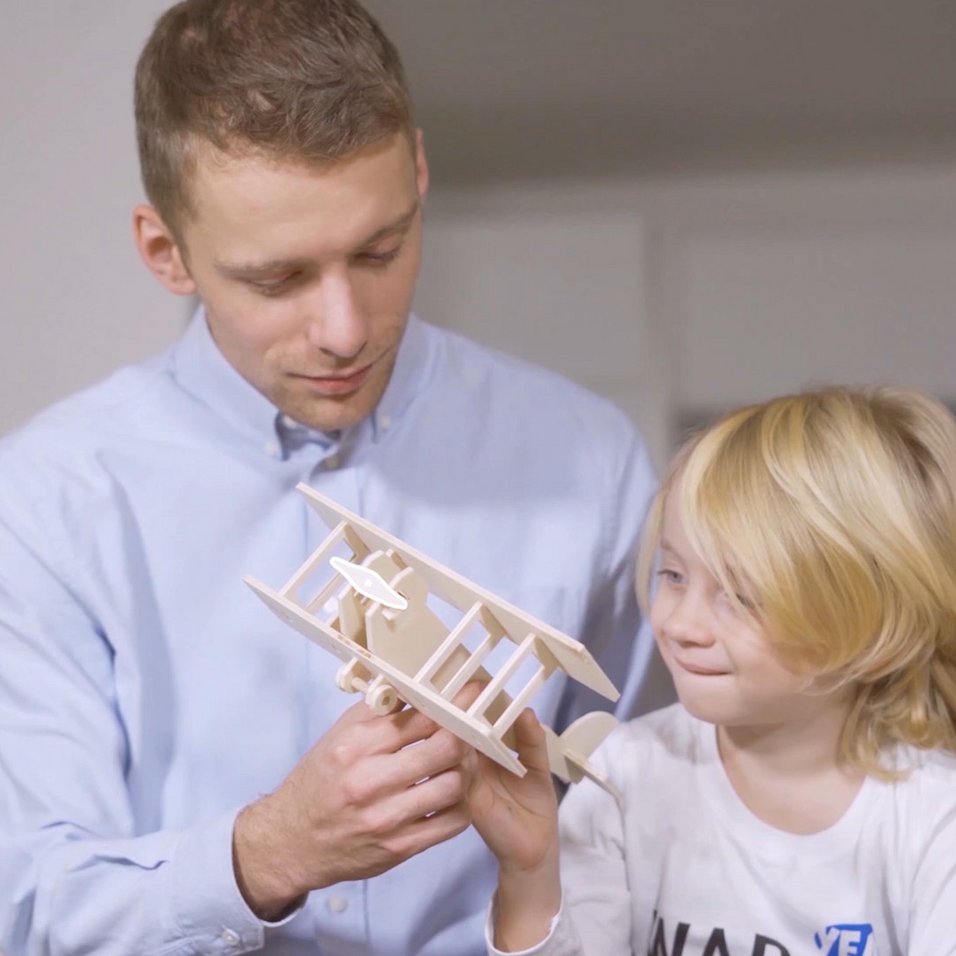 father with child looking at a model made with playmake