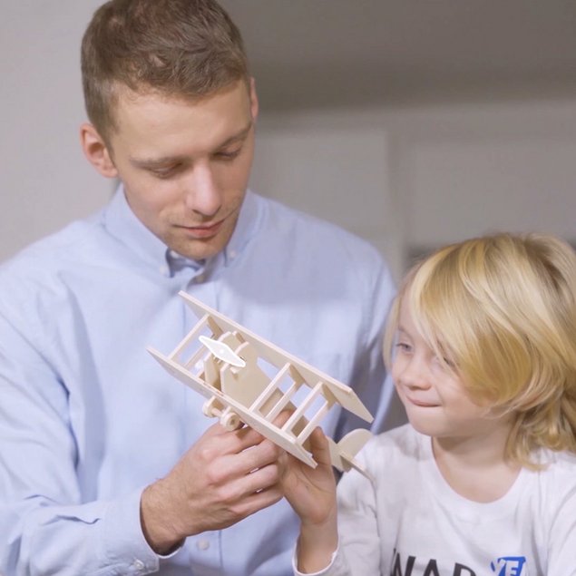 father with child looking at a model made with playmake