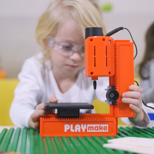Child assembles the PLAYmake drill press on a table